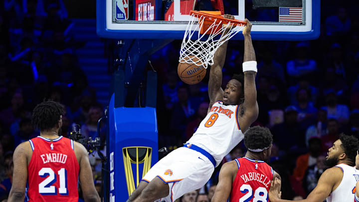 Nov 12, 2024; Philadelphia, Pennsylvania, USA; New York Knicks forward OG Anunoby (8) dunks the ball in front of Philadelphia 76ers center Joel Embiid (21) and forward Guerschon Yabusele (28) during the fourth quarter at Wells Fargo Center. Mandatory Credit: Bill Streicher-Imagn Images