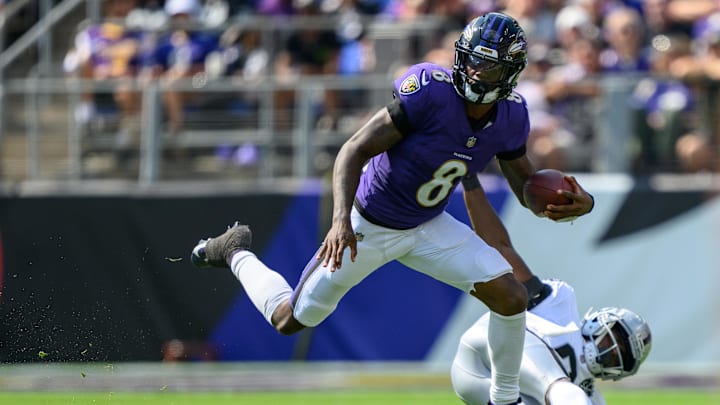 Baltimore Ravens quarterback Lamar Jackson leaps over Las Vegas Raiders cornerback Jakorian Bennett. Mandatory Credit: Reggie Hildred-Imagn Images