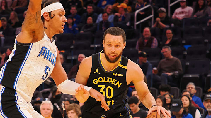 Golden State Warriors guard Stephen Curry (30) drives in against Orlando Magic forward Paolo Banchero (5) during the third quarter at Chase Center.