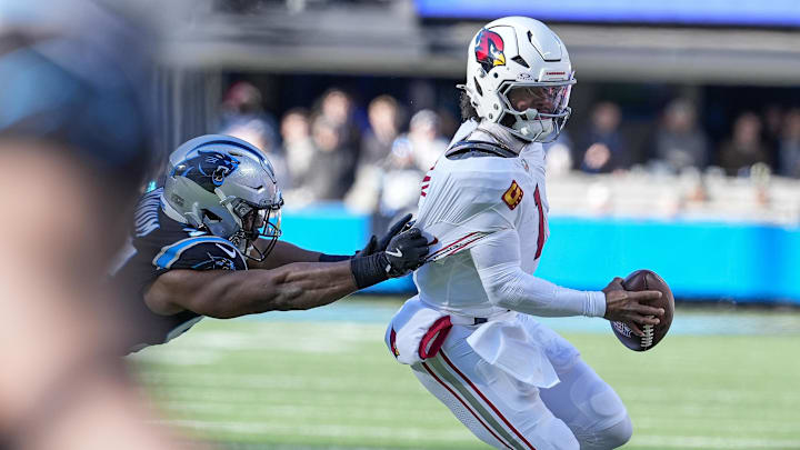 Dec 22, 2024; Charlotte, North Carolina, USA; Arizona Cardinals quarterback Kyler Murray (1) is grabbed by Carolina Panthers linebacker D.J. Wonnum (98) during the second quarter at Bank of America Stadium. Mandatory Credit: Jim Dedmon-Imagn Images