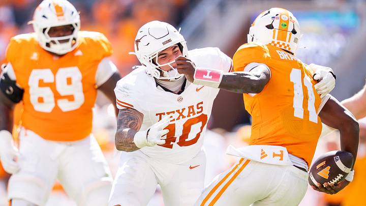Texas Longhorns edge Lance Jackson (40) tries to take down Tennessee quarterback Faizon Brandon (11) as Tennessee offensive lineman Donovan Haslam (69) watches during a college football game between Tennessee and Texas at Neyland Stadium in Knoxville, Tenn. on Sept. 26, 2026. Texas Longhorns edge Lance Jackson (40) tries to take down Tennessee quarterback Faizon Brandon (11) as Tennessee offensive lineman Donovan Haslam (69) watches during a college football game between Tennessee and Texas at Neyland Stadium in Knoxville, Tenn. on Sept. 26, 2026.