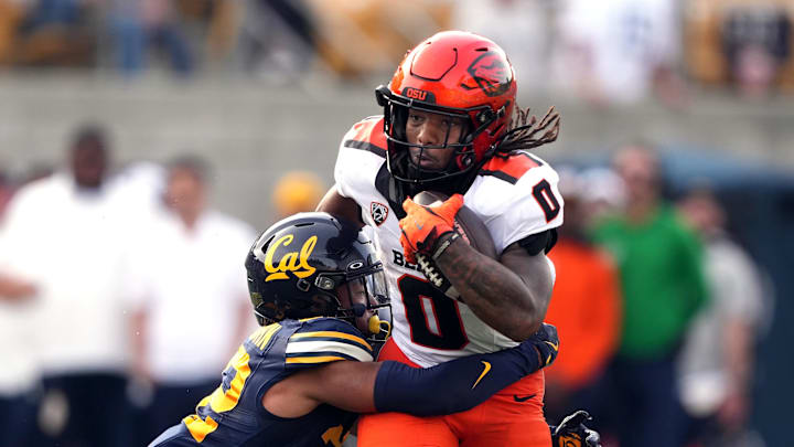 Oct 26, 2024; Berkeley, California, USA; Oregon State Beavers running back Anthony Hankerson (0) is tackled by California Golden Bears defensive back Matthew Littlejohn (left) during the fourth quarter at California Memorial Stadium. Mandatory Credit: Darren Yamashita-Imagn Images Oct 26, 2024; Berkeley, California, USA; Oregon State Beavers running back Anthony Hankerson (0) is tackled by California Golden Bears defensive back Matthew Littlejohn (left) during the fourth quarter at California Memorial Stadium. Mandatory Credit: Darren Yamashita-Imagn Images