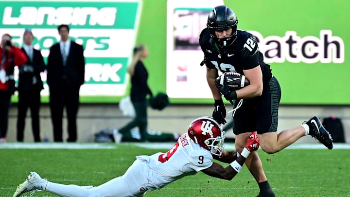 Nov 2, 2024; East Lansing, Michigan, USA;  Michigan State Spartans tight end Jack Velling (12) evades Indiana Hoosiers defensive back Jamier Johnson (9) during the third quarter at Spartan Stadium. Mandatory Credit: Dale Young-Imagn Images