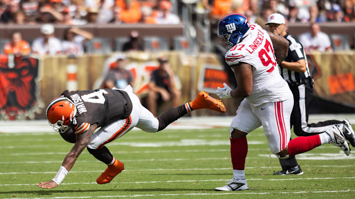 Sep 22, 2024; Cleveland, Ohio, USA; Cleveland Browns quarterback Deshaun Watson (4) stumbles away from New York Giants defensive tackle Dexter Lawrence II (97) during the second quarter at Huntington Bank Field. 
