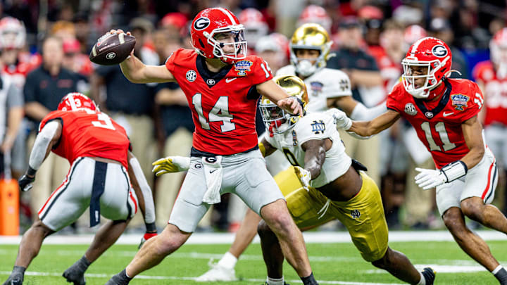 Jan 2, 2025; New Orleans, LA, USA;  Georgia Bulldogs quarterback Gunner Stockton (14) passes against Notre Dame Fighting Irish defensive lineman RJ Oben (9) during the second half at Caesars Superdome. Mandatory Credit: Stephen Lew-Imagn Images