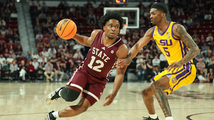 Mar 1, 2025; Starkville, Mississippi, USA; Mississippi State Bulldogs guard Josh Hubbard (12) drives to the basket against LSU Tigers guard Cam Carter (5) during the second half at Humphrey Coliseum. Mandatory Credit: Wesley Hale-Imagn Images