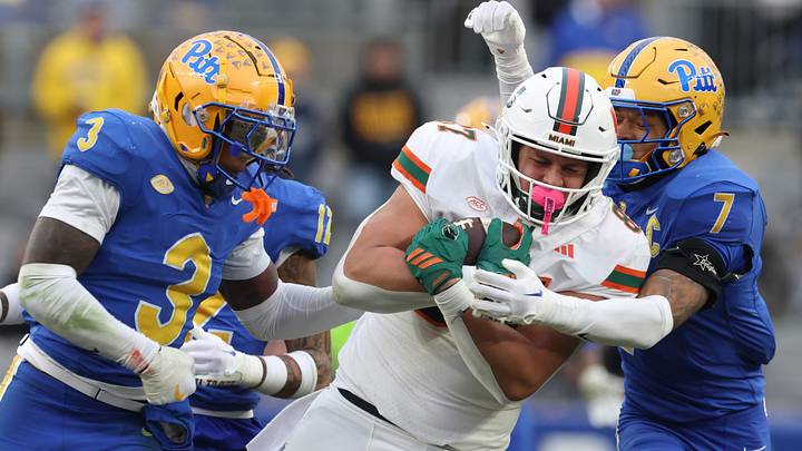 Nov 29, 2025; Pittsburgh, Pennsylvania, USA; Miami Hurricanes tight end Alex Bauman (87) runs after a catch as Pittsburgh Panthers linebacker Rasheem Biles (3) and defensive back Javon McIntyre (7) defend during the third quarter at Acrisure Stadium. Mandatory Credit: Charles LeClaire-Imagn Images Nov 29, 2025; Pittsburgh, Pennsylvania, USA; Miami Hurricanes tight end Alex Bauman (87) runs after a catch as Pittsburgh Panthers linebacker Rasheem Biles (3) and defensive back Javon McIntyre (7) defend during the third quarter at Acrisure Stadium. Mandatory Credit: Charles LeClaire-Imagn Images