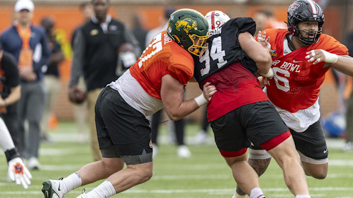 Jan 30, 2025; Mobile, AL, USA; National team offensive lineman Grey Zabel of North Dakota State (77) and National team offensive lineman Caleb Rogers of Texas Tech (76) battle with National team defensive lineman Ty Robinson of Nebraska (94) during Senior Bowl practice for the National team at Hancock Whitney Stadium.