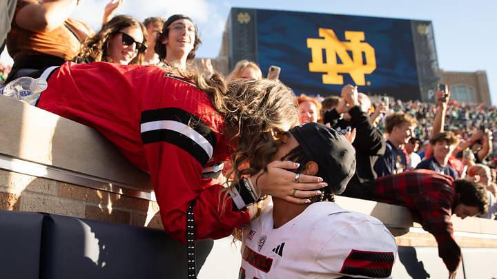 Northern Illinois linebacker Jaden Dolphin kisses his girlfriend Ruby Mendez Toomey after winning a NCAA college football game 16-14 against Notre Dame at Notre Dame Stadium on Saturday, Sept. 7, 2024, in South Bend.
