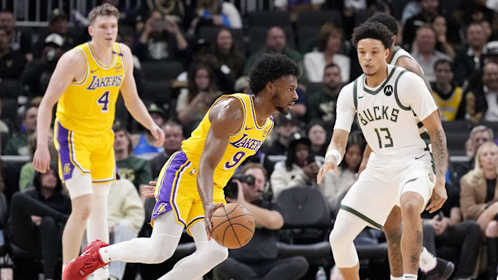Oct 10, 2024; Milwaukee, Wisconsin, USA; Los Angeles Lakers guard Bronny James (9) drives against Milwaukee Bucks guard Ryan Rollins (13) in the second half at Fiserv Forum. Mandatory Credit: Michael McLoone-Imagn Images