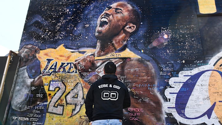 Jan 26, 2021; Los Angeles, California, USA; Caesar Mendoza takes a snapshot of a mural of Kobe Bryant in an alley near Staples Center in downtown Los Angeles. Bryant and his daughter Gianna and seven other persons died in a helicopter crash on Jan. 26, 2020. Mandatory Credit: Robert Hanashiro-Imagn Images