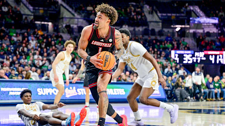 Feb 16, 2025; South Bend, Indiana, USA; Louisville Cardinals guard J'Vonne Hadley (1) drives to the basket as Notre Dame Fighting Irish guard Markus Burton (3) and forward Kebba Njie (14) defend in the second half at the Purcell Pavilion. Mandatory Credit: Matt Cashore-Imagn Images Feb 16, 2025; South Bend, Indiana, USA; Louisville Cardinals guard J'Vonne Hadley (1) drives to the basket as Notre Dame Fighting Irish guard Markus Burton (3) and forward Kebba Njie (14) defend in the second half at the Purcell Pavilion. Mandatory Credit: Matt Cashore-Imagn Images