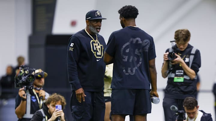 Apr 4, 2025; Boulder, CO, USA; Colorado Buffaloes head coach Deion Sanders talks to his son, Colorado Buffaloes quarterback Shedeur Sanders (2), at the University of Colorado NFL Showcase at the CU Indoor Practice Facility. Mandatory Credit: Michael Ciaglo-Imagn Images