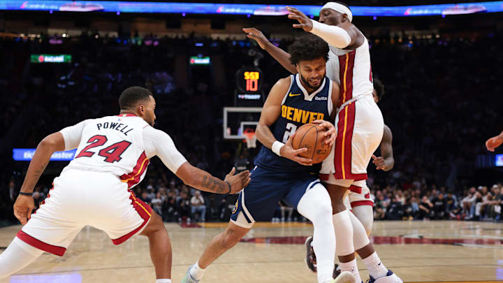 Dec 29, 2025; Miami, Florida, USA; Denver Nuggets guard Jamal Murray (27) drives to the basket against Miami Heat center Bam Adebayo (13) and guard Norman Powell (24) during the second quarter at Kaseya Center. Mandatory Credit: Sam Navarro-Imagn Images