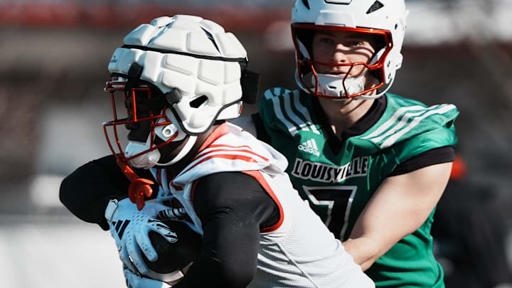 Louisville RB Isaac Brown (1) takes a hand off from QB Miller Moss (7) during practice outside the Trager Center in Louisville, Ky. on Mar. 1, 2025. Louisville RB Isaac Brown (1) takes a hand off from QB Miller Moss (7) during practice outside the Trager Center in Louisville, Ky. on Mar. 1, 2025.