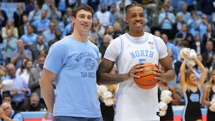 Jan 21, 2023; Chapel Hill, North Carolina, USA; Former North Carolina Tar Heels great Tyler Hansbrough presents forward Armando Bacot (5) with the game ball after the game. Bacot became the all-time Tar Heels rebounding leader during the game breaking Hansbrough   s record. Mandatory Credit: Bob Donnan-Imagn Images