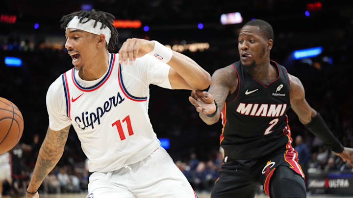 Mar 12, 2025; Miami, Florida, USA;  LA Clippers guard Jordan Miller (11) saves the ball from going out of bounds in front of Miami Heat guard Terry Rozier (2) during the second half at Kaseya Center. Mandatory Credit: Jim Rassol-Imagn Images