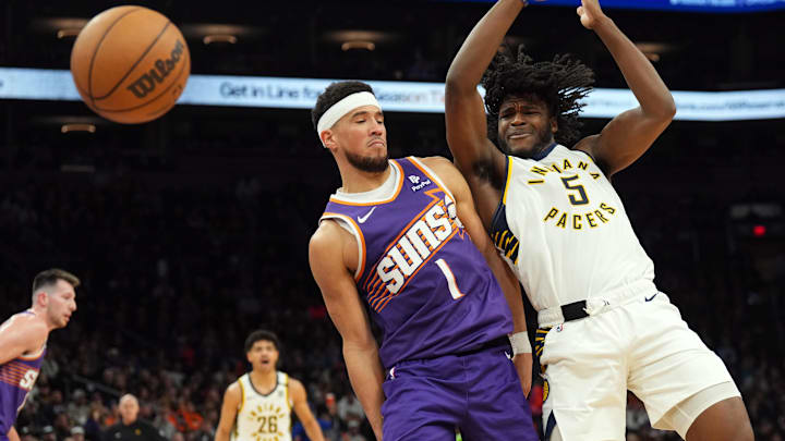 Jan 21, 2024; Phoenix, Arizona, USA; Indiana Pacers forward Jarace Walker (5) loses control of the ball against Phoenix Suns guard Devin Booker (1) during the second half at Footprint Center. Mandatory Credit: Joe Camporeale-Imagn Images