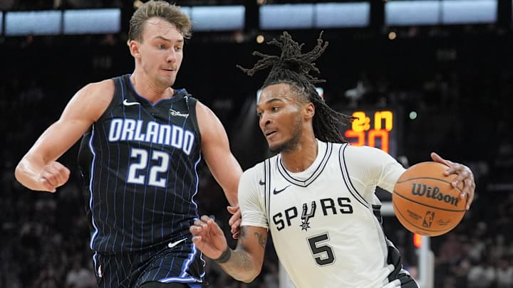 Oct 9, 2024; San Antonio, Texas, USA;  San Antonio Spurs guard Stephon Castle (5) dribbles against Orlando Magic forward Franz Wagner (22) in the first half at Frost Bank Center. Mandatory Credit: Daniel Dunn-Imagn Images
