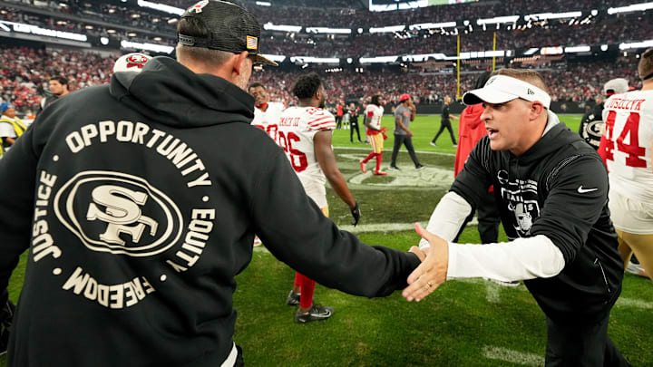 San Francisco 49ers head coach Kyle Shanahan (L) greets Las Vegas Raiders head coach Josh McDaniels (R).