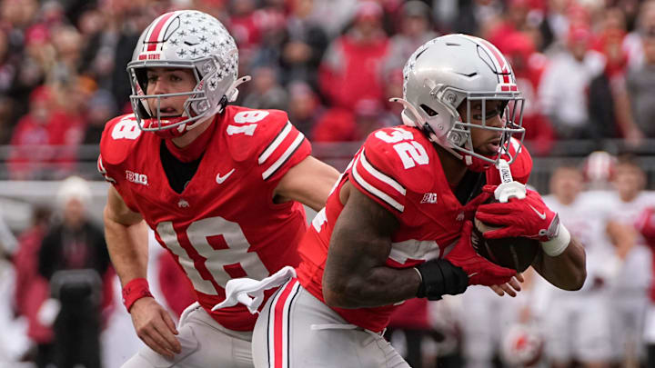 Ohio State Buckeyes quarterback Will Howard (18) hands off to running back TreVeyon Henderson (32) 