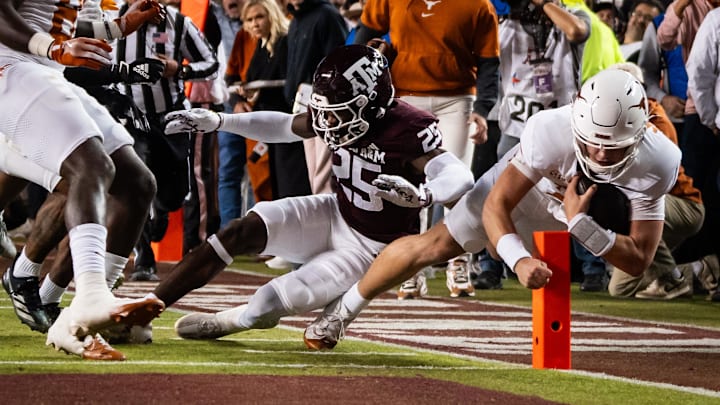 Nov 30, 2024; College Station, Texas, USA; Texas Longhorns quarterback Arch Manning (16) dives for a touchdown against Texas A&M Aggies defensive back Dalton Brooks (25) in the first quarter at Kyle Field. The touchdown was awarded after a review of the play. Mandatory Credit: Sara Diggins/USA TODAY Network via Imagn Images