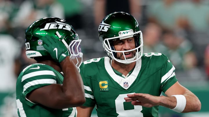 Sep 19, 2024; East Rutherford, New Jersey, USA; New York Jets quarterback Aaron Rodgers (8) talks to running back Breece Hall (20) during warmups before a game against the New England Patriots at MetLife Stadium.