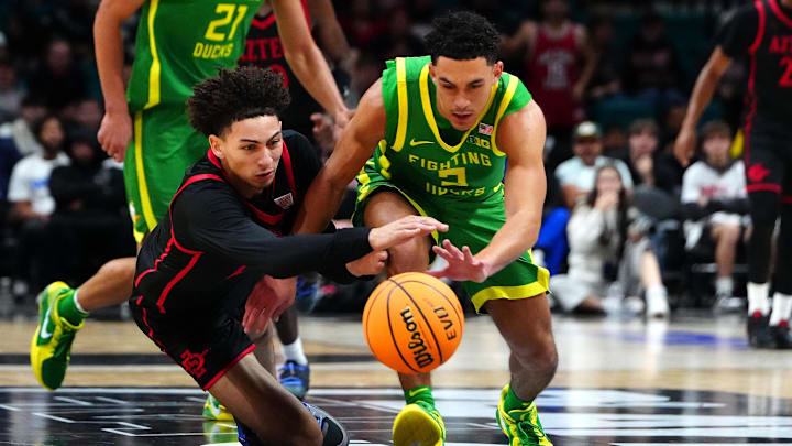 Nov 27, 2024; Las Vegas, Nevada, USA; San Diego State Aztecs guard Miles Byrd (21) and Oregon Ducks guard Jadrian Tracey (2) vie for a loose ball during the second half at MGM Grand Garden Arena. Mandatory Credit: Stephen R. Sylvanie-Imagn Images