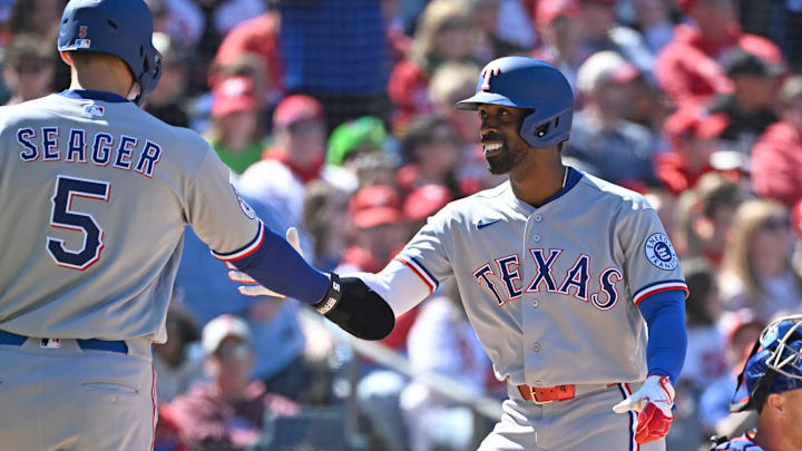 Texas Rangers center fielder Andrew McCutchen (4) celebrates his three run home run with shortstop Corey Seager.