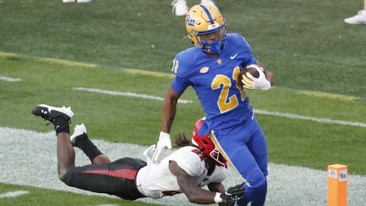 Sep 21, 2024; Pittsburgh, Pennsylvania, USA;  Pittsburgh Panthers wide receiver Che Nwabuko (21) runs into the end zone to score a touchdown against Youngstown State Penguins defensive back DJ Harris (left) during the fourth quarter at Acrisure Stadium. Mandatory Credit: Charles LeClaire-Imagn Images