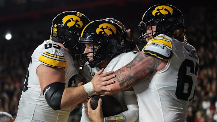 Sep 19, 2025; Piscataway, New Jersey, USA; Iowa Hawkeyes quarterback Mark Gronowski (11) celebrates with teammates after scoring a rushing touchdown during the first half against the Rutgers Scarlet Knights at SHI Stadium. Mandatory Credit: Vincent Carchietta-Imagn Images