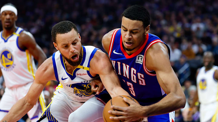 Feb 21, 2025; Sacramento, California, USA; Sacramento Kings forward Keegan Murray (13) and Golden State Warriors guard Stephen Curry (30) fight for a rebound during the first quarter at Golden 1 Center.