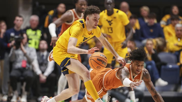 Jan 13, 2024; Morgantown, West Virginia, USA; West Virginia Mountaineers forward Ofri Naveh (9) and Texas Longhorns forward Dillon Mitchell (23) dive for the ball during the first half at WVU Coliseum. Mandatory Credit: Ben Queen-Imagn Images