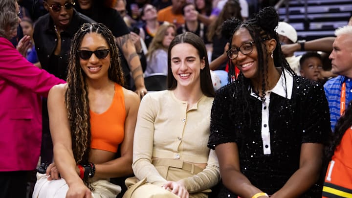 Jul 19, 2024; Phoenix, AZ, USA; WNBA All-stars Aerial Powers, Caitlin Clark and Aliyah Boston look on from the sidelines during the WNBA All-Star Skills Night at the Footprint Center. Mandatory Credit: Mark J. Rebilas-Imagn Images