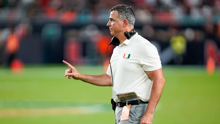 Nov 8, 2025; Miami Gardens, Florida, USA; Miami Hurricanes head coach Mario Cristobal gives his team instructions against the Syracuse Orange during the third quarter at Hard Rock Stadium. Mandatory Credit: Jeff Romance-Imagn Images Nov 8, 2025; Miami Gardens, Florida, USA; Miami Hurricanes head coach Mario Cristobal gives his team instructions against the Syracuse Orange during the third quarter at Hard Rock Stadium. Mandatory Credit: Jeff Romance-Imagn Images