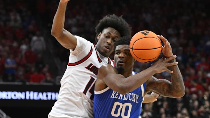 Nov 11, 2025; Louisville, Kentucky, USA;  Kentucky Wildcats guard Otega Oweh (00) drives to the basket against Louisville Cardinals guard Adrian Wooley (14) during the first half at KFC Yum! Center. Mandatory Credit: Jamie Rhodes-Imagn Images