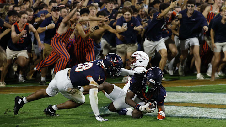 Virginia fans storm the field after their team made a game-winning interception in the end zone on a pass intended for Florida State Seminoles wide receiver Squirrel White (4) in the second overtime at Scott Stadium.