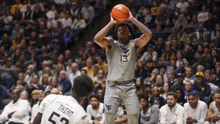Mar 8, 2025; Morgantown, West Virginia, USA; West Virginia Mountaineers forward Amani Hansberry (13) shoots a three pointer during the first half against the UCF Knights at WVU Coliseum. Mandatory Credit: Ben Queen-Imagn Images