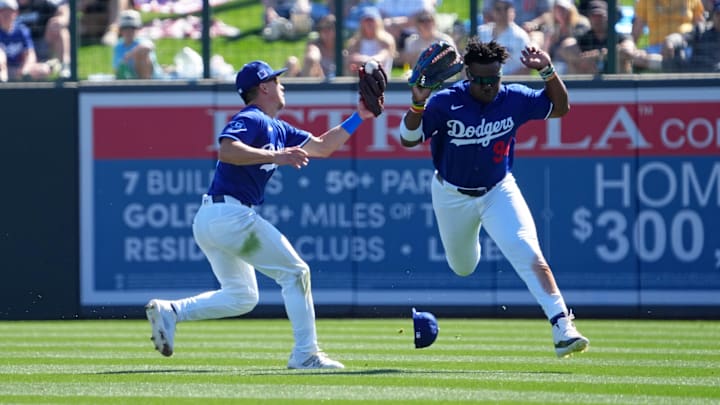 Feb 23, 2025; Phoenix, Arizona, USA; Los Angeles Dodgers outfielder Tommy Edman (25) makes a catch on a pop-up while avoiding teammate right fielder Zyhir Hope (94) during the third inning at Camelback Ranch-Glendale. Mandatory Credit: Joe Camporeale-Imagn Images