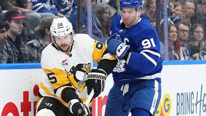 Apr 8, 2024; Toronto, Ontario, CAN; Toronto Maple Leafs center John Tavares (91) battles for the puck with Pittsburgh Penguins defenseman Erik Karlsson (65) during the third period at Scotiabank Arena. Mandatory Credit: Nick Turchiaro-USA TODAY Sports