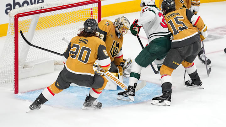 Apr 20, 2025; Las Vegas, Nevada, USA; Vegas Golden Knights goaltender Adin Hill (33) makes a save as Minnesota Wild right wing Ryan Hartman (38) looks for a rebound during the third period of game one of the first round of the 2025 Stanley Cup Playoffs at T-Mobile Arena. Mandatory Credit: Stephen R. Sylvanie-Imagn Images