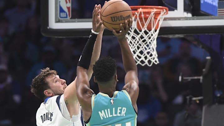 Apr 9, 2024; Charlotte, North Carolina, USA;  Dallas Mavericks guard Luka Doncic (77) defends Charlotte Hornets forward guard Brandon Miller (24) during the first half at the Spectrum Center. Mandatory Credit: Sam Sharpe-USA TODAY Sports