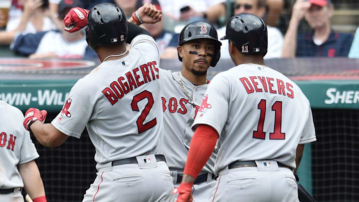 Former Boston Red Sox shortstop Xander Bogaerts (2) celebrates with right fielder Mookie Betts (middle) and third baseman Rafael Devers (11) after hitting a three-run home run against the Cleveland Indians during the seventh inning at Progressive Field.