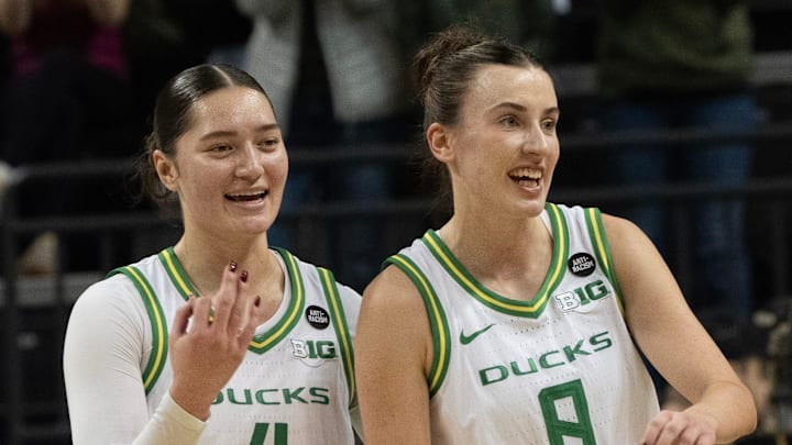 Oregon’s Nani Falatea, left, and Elisa Mevius celebrate as they leave the court in the lead against Wisconsin at the half.