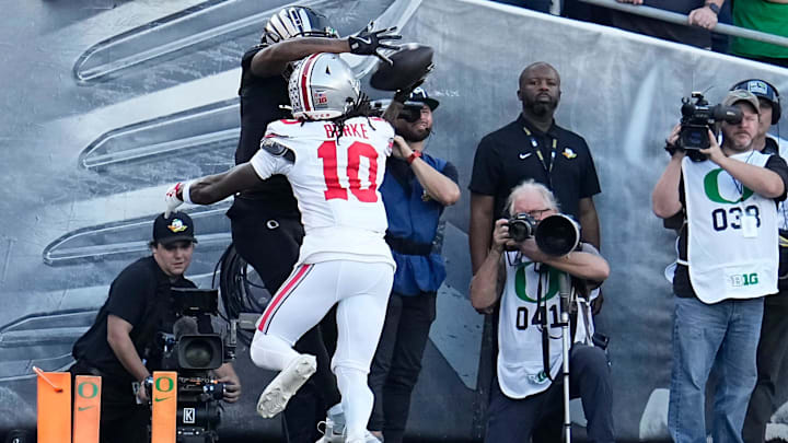 Oct 12, 2024; Eugene, Oregon, USA; Oregon Ducks wide receiver Evan Stewart (7) catches a touchdown over Ohio State Buckeyes cornerback Denzel Burke (10) during the first half of the NCAA football game at Autzen Stadium