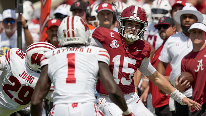 Sep 13, 2025; Tuscaloosa, Alabama, USA;  Alabama quarterback Ty Simpson (15) tries to avoid a tackle by Wisconsin defensive back Matthew Jung (29) and Wisconsin defensive back Geimere Latimer II (1) at Saban Field at Bryant-Denny Stadium. 