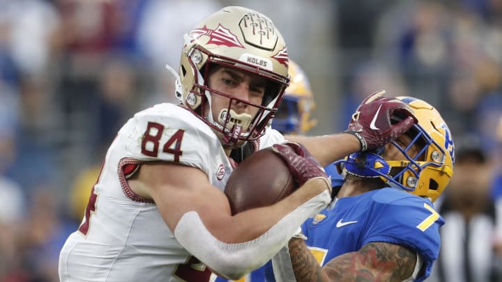 Nov 4, 2023; Pittsburgh, Pennsylvania, USA; Florida State Seminoles tight end Kyle Morlock (84) stiff arms Pittsburgh Panthers defensive back Javon McIntyre (7) after a catch during the second quarter at Acrisure Stadium. Mandatory Credit: Charles LeClaire-USA TODAY Sports Nov 4, 2023; Pittsburgh, Pennsylvania, USA; Florida State Seminoles tight end Kyle Morlock (84) stiff arms Pittsburgh Panthers defensive back Javon McIntyre (7) after a catch during the second quarter at Acrisure Stadium. Mandatory Credit: Charles LeClaire-USA TODAY Sports