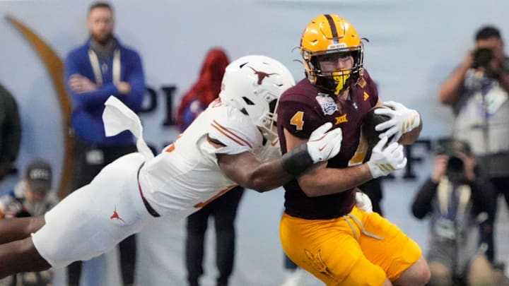 Arizona State running back Cam Skattebo (4) is tackled by Texas linebacker Colin Simmons (11) during the fourth quarter in the Chick-fil-A Peach Bowl in Atlanta on Wednesday, Jan. 1, 2025. Arizona State running back Cam Skattebo (4) is tackled by Texas linebacker Colin Simmons (11) during the fourth quarter in the Chick-fil-A Peach Bowl in Atlanta on Wednesday, Jan. 1, 2025.