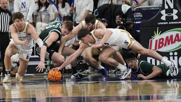Jan 12, 2025; Evanston, Illinois, USA; Northwestern Wildcats guard Brooks Barnhizer (13) dives for a loose ball against the Michigan State Spartans during the second half at Welsh-Ryan Arena. Mandatory Credit: David Banks-Imagn Images
