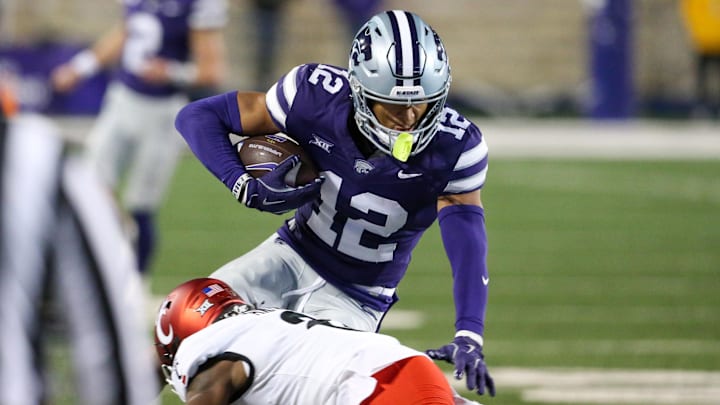 Nov 23, 2024; Manhattan, Kansas, USA; Kansas State Wildcats wide receiver Tre Spivey (12) is tackled by Cincinnati Bearcats cornerback Ormanie Arnold (8) during the third quarter at Bill Snyder Family Football Stadium. Mandatory Credit: Scott Sewell-Imagn Images